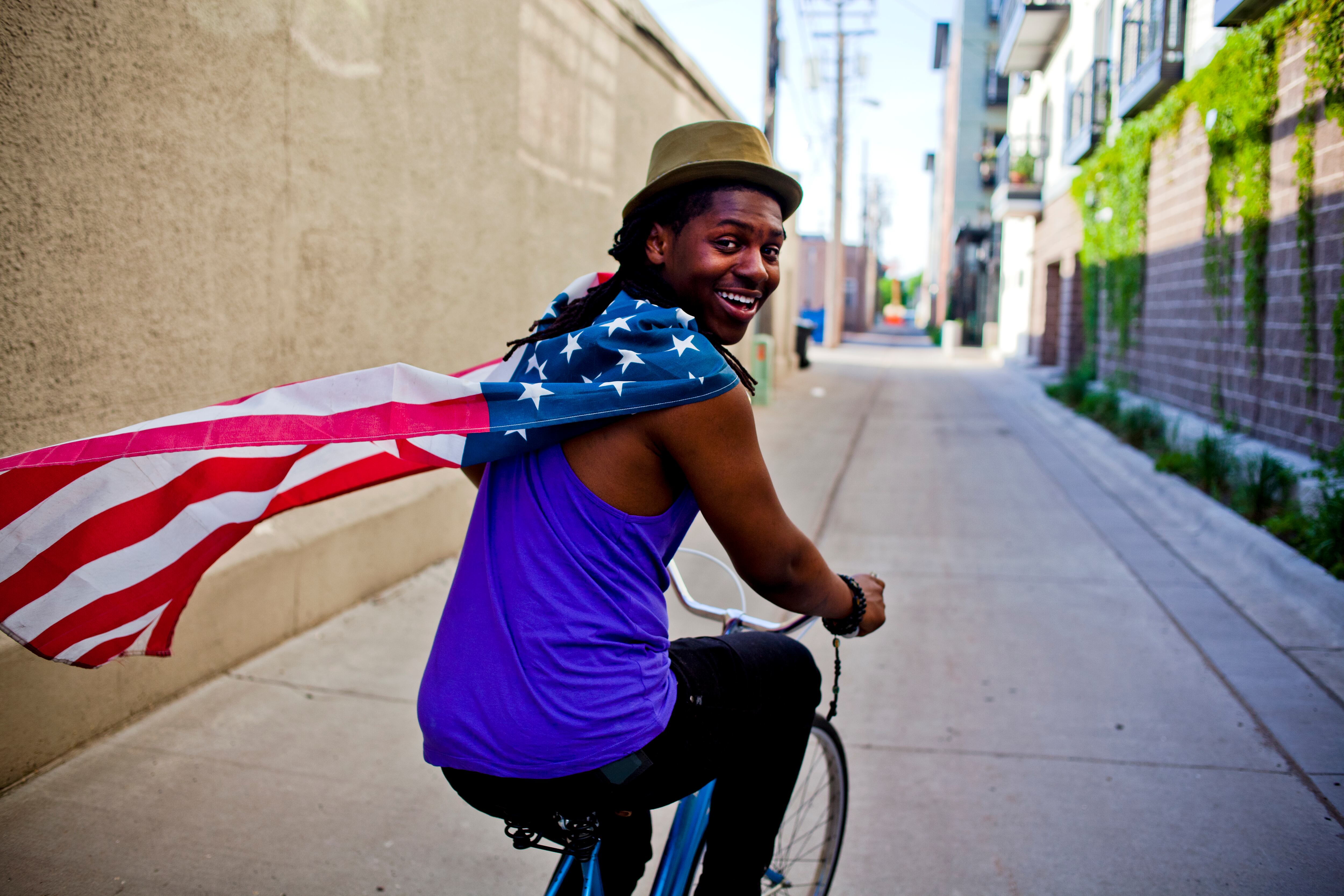 Un joven con una bandera estadounidense alrededor del cuello.