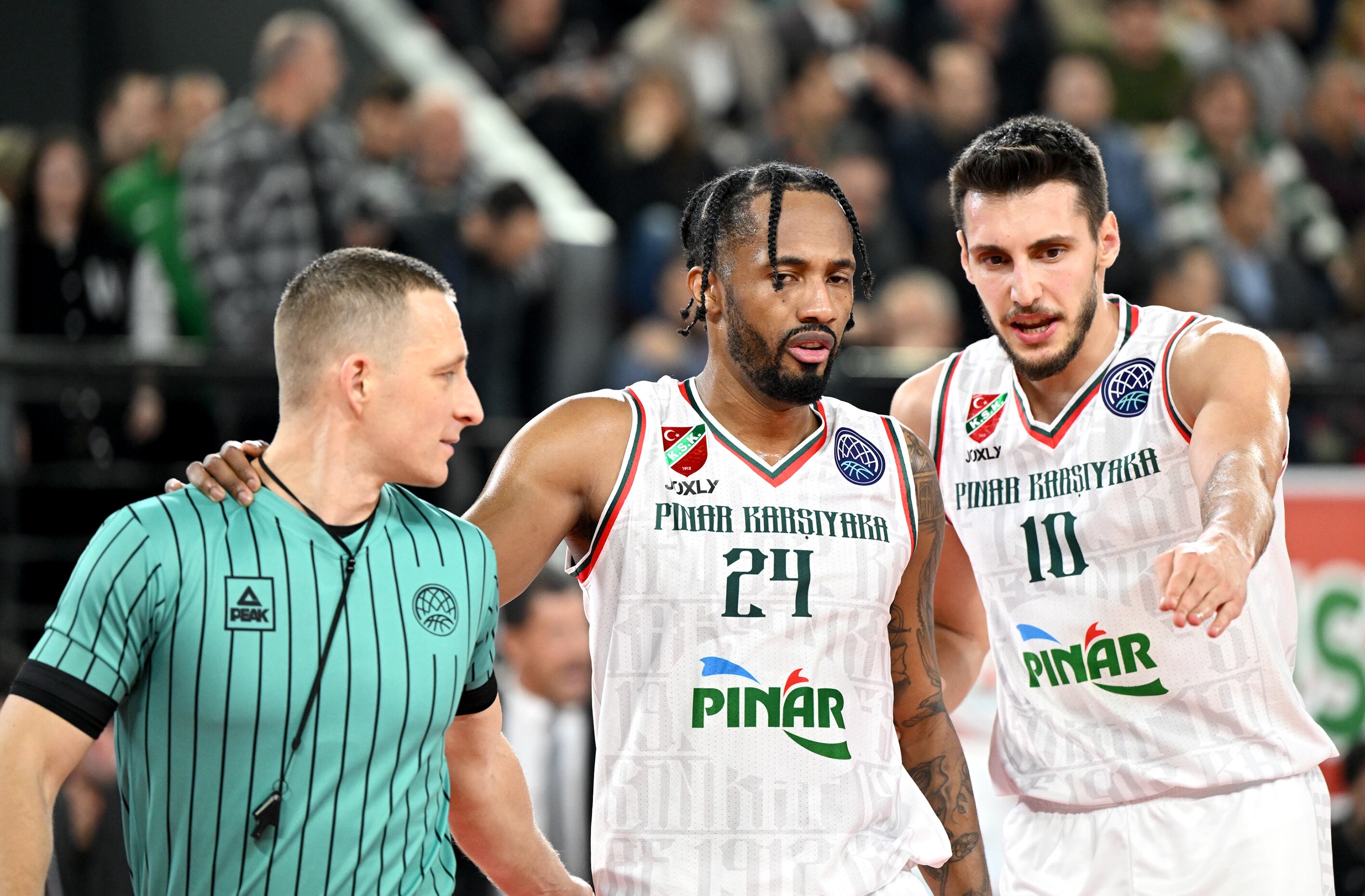 IZMIR, TURKIYE - JANUARY 11: Berkan Durmaz (R) and Braian Angola (C) of Pinar Karsiyaka chat with the referee Martins Kozlovskis (L) during basketball Champions League play in match between Pinar Karsiyaka and UCSM Murcia at Mustafa Kemal Ataturk Karsiyaka Sports Complex in Izmir, Turkiye on January 11, 2023. (Photo by Mahmut Serdar Alakus/Anadolu Agency via Getty Images)