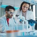 Laboratorio de Investigación Médica Moderna: Retrato de Jóvenes Científicos Latinos y Negros Usando Microscopio, Tableta Digital, Haciendo Análisis de Muestras, Hablando. Diverso equipo de especialistas trabajan en Advanced Lab