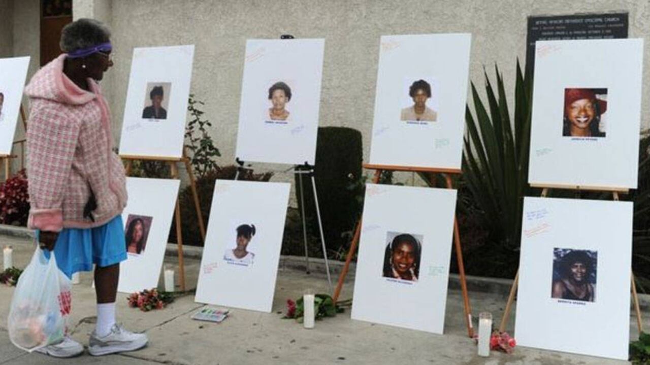 Una mujer observa las fotos de las víctimas de un asesino seria que se llamado como "El nefasto durmiente" (Grimm Sleeper).