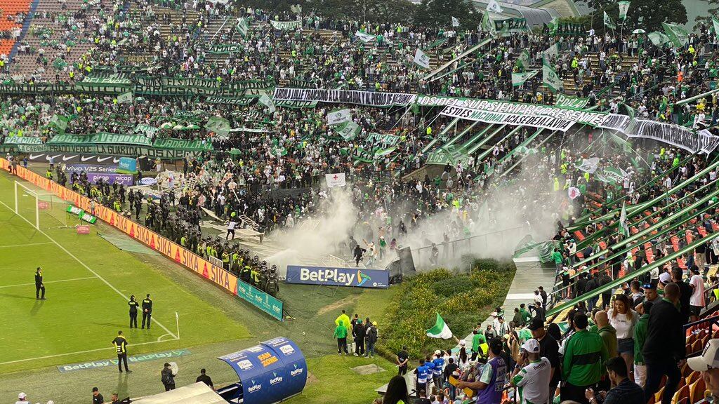 Momento en el que agentes del ESMAD y barristas de Atlético Nacional se enfrentan en la tribuna sur