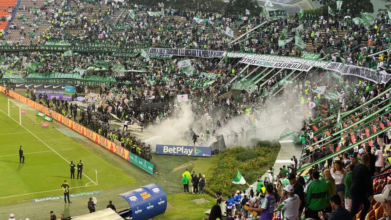 Momento en el que agentes del ESMAD y barristas de Atlético Nacional se enfrentan en la tribuna sur