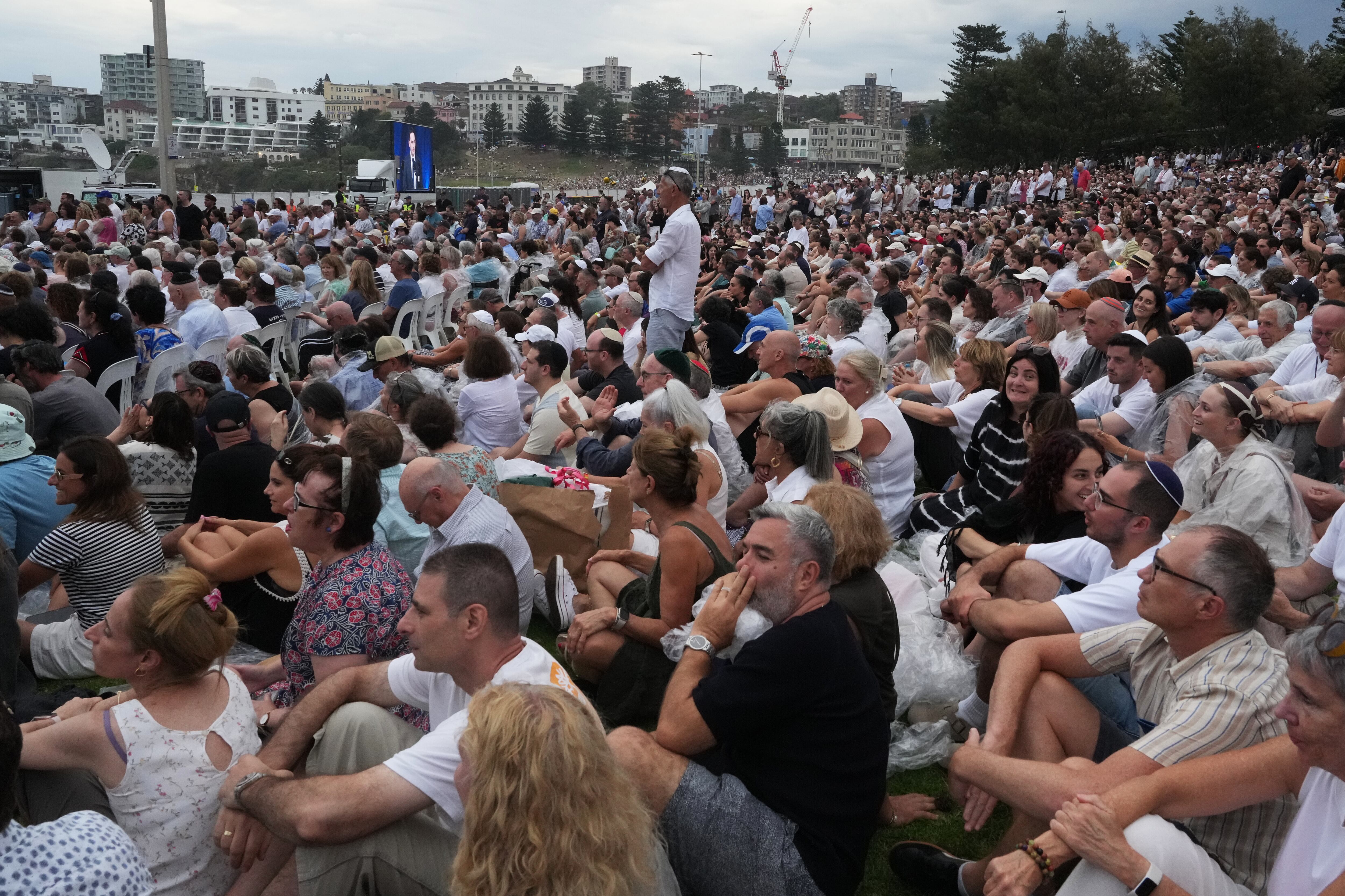 Los asistentes escuchan a David Ossip, presidente de la Junta de Diputados Judíos de Nueva Gales del Sur, durante una ceremonia para conmemorar el Día Nacional de Reflexión por las víctimas y los sobrevivientes, en Bondi Beach, Sídney.