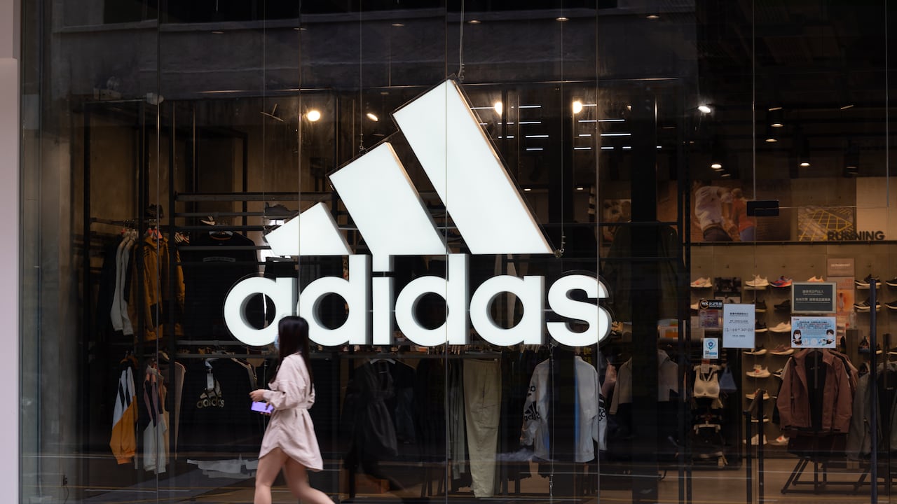 Una mujer pasa frente a la tienda Adidas en Hong Kong.