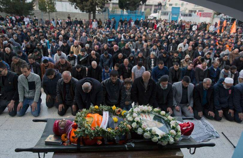 Los dolientes oran junto al cuerpo de Sajed Mizher, joven que, según el  Ministerio de Salud palestino fue abatido a tiros en los enfrentamientos con las tropas israelíes. FOTO: Nasser Nasser/AP