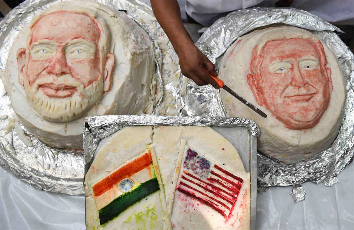 Iniyan, de 49 años, termina un idili, pastel de arroz, decorado con los rostros de los mandatario y las banderas de los respectivos países. Foto: Arun Sankar/ AFP. 