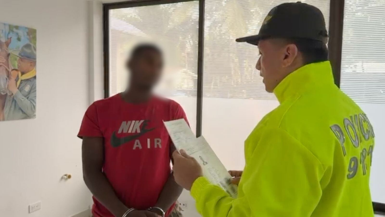 Un policía lee los derechos del capturado a un presunto cabecilla del Clan del Golfo.