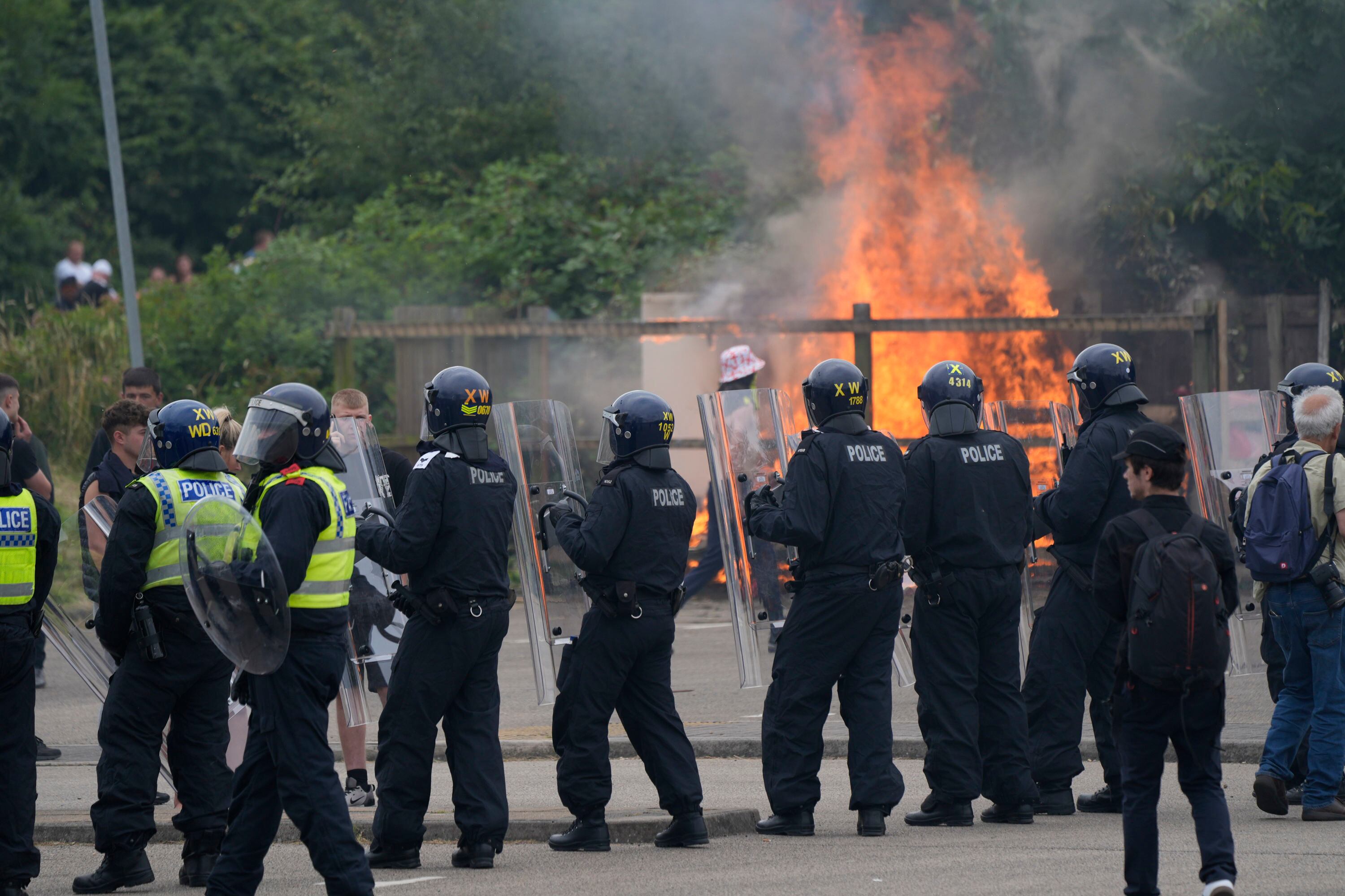 Oficiales de policía bloquean a los manifestantes mientras estallan los problemas durante una manifestación contra la inmigración frente al Holiday Inn Express en Rotherham, Inglaterra, el domingo 4 de agosto de 2024. (Danny Lawson/PA vía AP)