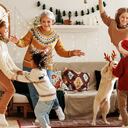 Feliz familia multirracial positiva con tres hijos y golden retriever divertirse el día de Navidad en casa. Madre, abuela y niños multiétnicos bailan con música de Año Nuevo durante las vacaciones de invierno