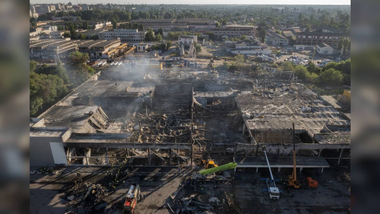 Bomberos del Servicio Ucraniano de Emergencias trabajan para retirar los escombros de un centro comercial calcinado tras el impacto de un cohete de en Kremenchuk, Ucrania, el martes 28 de junio de 2022. Foto: AP/Efrem Lukatsky.