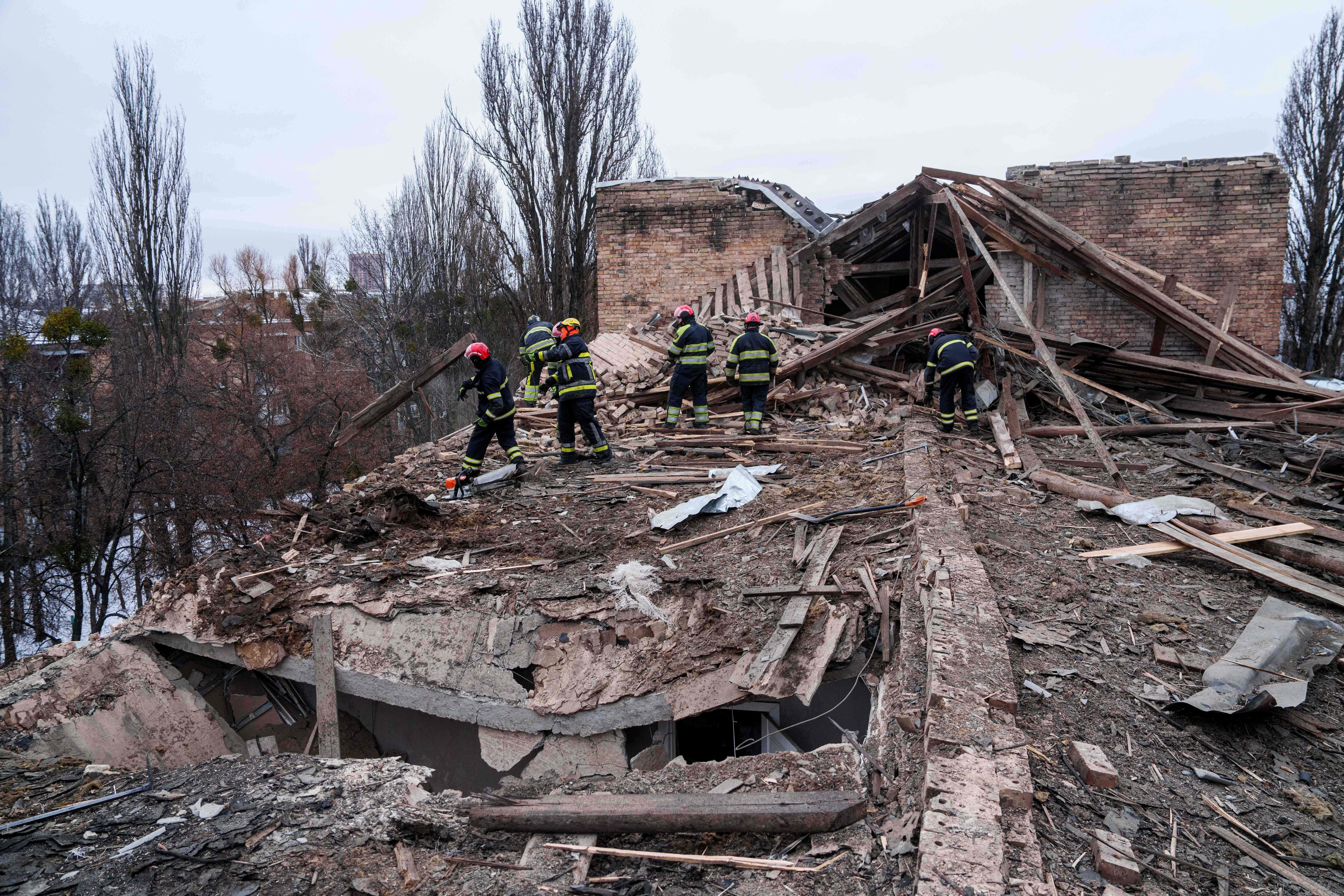 Los rescatistas retiran los escombros del tejado de un edificio de apartamentos dañado tras un ataque ruso en Kiev, Ucrania.