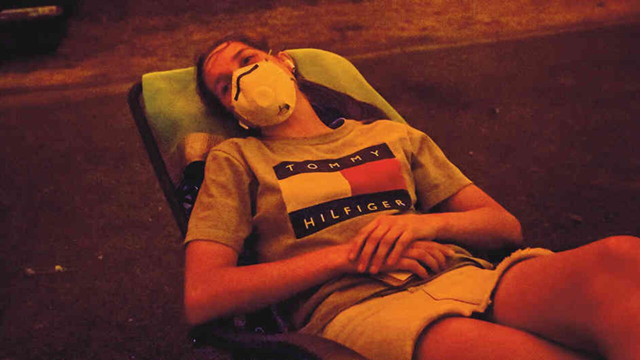 Una joven, Sarah Pontifex, posa para un retrato el 3 de enero de 2020 a medida que el cielo se pone rojo sangre en Mallacoota, a raíz de los incendios en Australia.