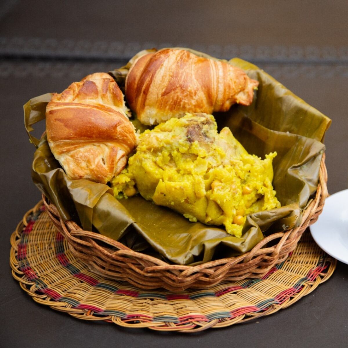 Su preparación, que incluye masa de maíz mezclada con arroz, arveja amarilla, zanahoria y una base generosa de cebolla y tomate.