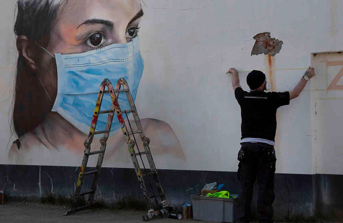 Bram de Ceurt trabaja en un grafiti callejero de una enfermera con una máscara bucal para protegerse contra el coronavirus en Amberes, Bélgica, el 26 de marzo. El país de Europa Occidental ya registra más de 6.200 casos. Foto: Virginia Mayo/ AP. 