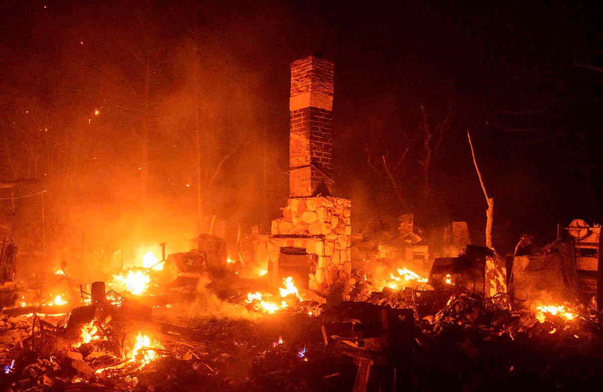 Una chimenea se quema entre los restos humeantes de una residencia mientras el lago Fire arde en el Bosque Nacional Ángeles, al norte de Santa Clarita, el jueves 13 de agosto de 2020. Foto: Noah Berger / AP 