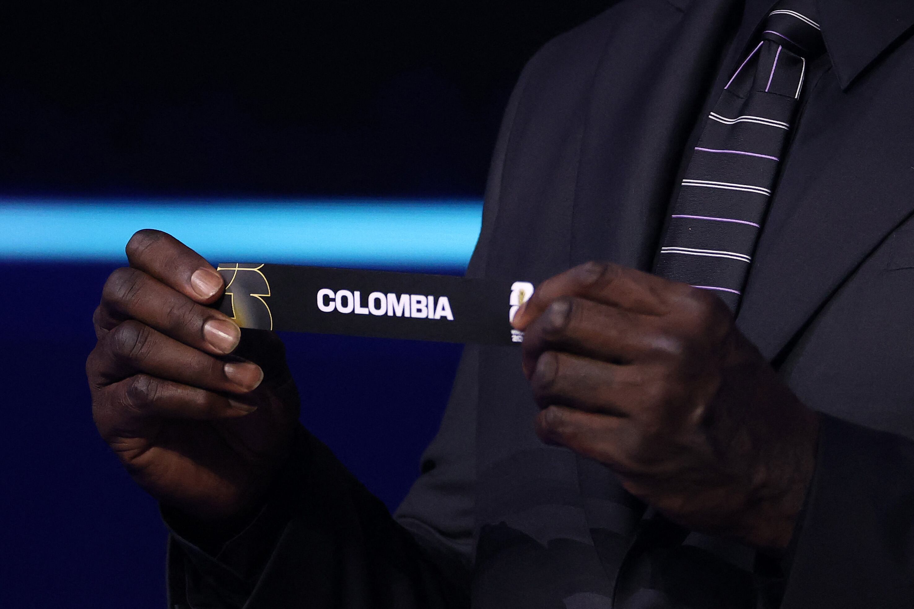 El asistente de sorteo Shaquille O'Neal saca la tarjeta de Colombia durante el sorteo oficial de la Copa Mundial de la FIFA 2026 en el Centro John F. Kennedy para las Artes Escénicas el 5 de diciembre de 2025 en Washington, D.C.