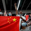 Supporters wave Chinese national flags as they wait for the arrival of Huawei executive Meng Wanzhou at the Bao'an International Airport in Shenzhen on September 25, 2021. (Photo by Noel Celis / AFP)