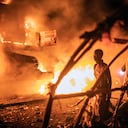 Personas caminan junto a vehículos de la ONU que fueron incendiados en Goma, República Democrática del Congo, el martes 1 de noviembre de 2022.