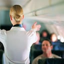 Rear View of Air Stewardess Explaining Aeroplane Safety to Passengers