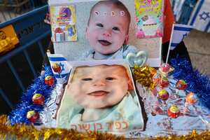 A supporter holds a cake with pictures of Kfir Bibas, the youngest hostage to be kidnapped by Hamas militants on the October 7 attack together with his mother and brother, as Israelis attend his first birthday celebration in Tel Aviv, on January 18, 2024. Kfir Bibas was born on January 18 and -- if still alive -- would be celebrating his first birthday. In November, Hamas broadcast a video announcing the death of the baby, his brother and mother, but there has been no confirmation from Israeli officials, and relatives are still clinging to the hope that they are not dead. (Photo by AHMAD GHARABLI / AFP)