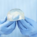 Implante mamario de silicona en manos del médico. Concepto de cirugía plástica de aumento de senos