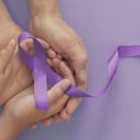 Manos de adultos y niños con cintas moradas, enfermedad de Alzheimer, cáncer de páncreas, conciencia de la epilepsia, día mundial del cáncer sobre fondo morado