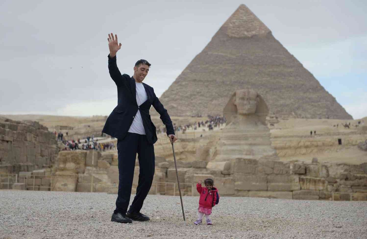 GIZA, Egipto Sultan Kosen (L), poseedor del récord mundial Guinness para el hombre más alto de 251 centímetros, y Jyoti Amge (R), la mujer viva más pequeña del mundo según Guinness World Records, posan para una foto en la pirámide de Giza complejo el 26 de enero de 2018. (Stringer - Agencia Anadolu).