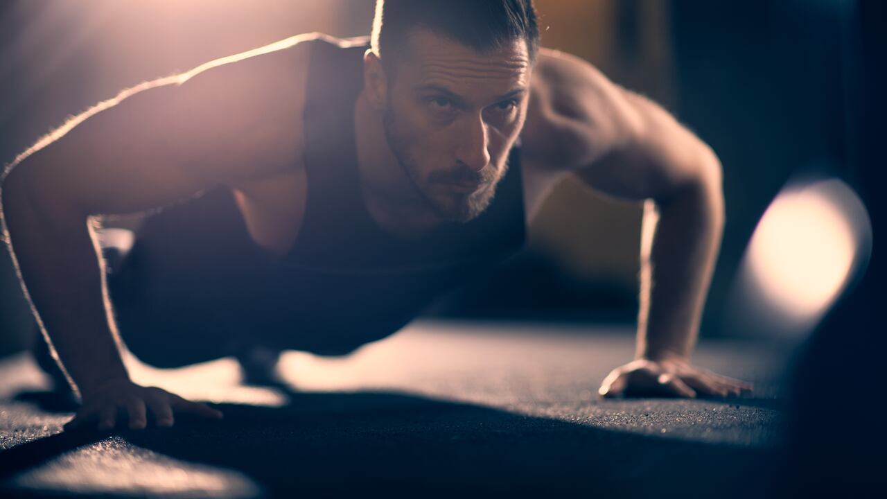 Caucasian athlete doing push-ups on floor