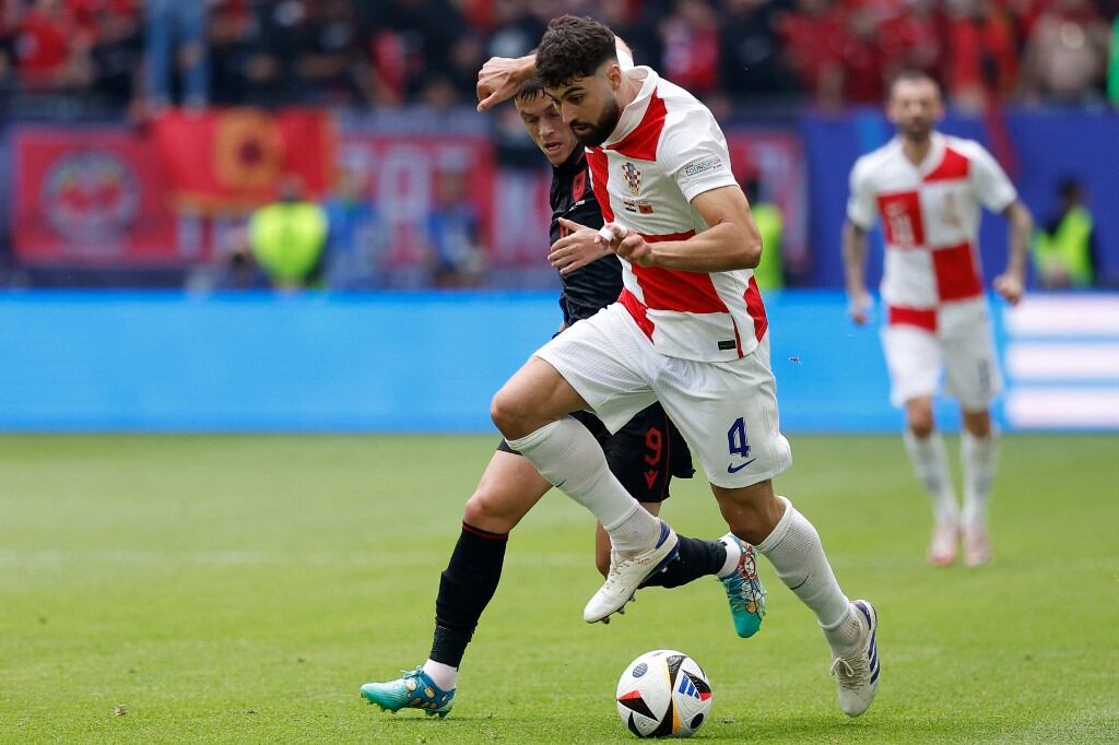 (De izquierda a derecha) El delantero de Albania #09 Jasir Asani y el defensor de Croacia #04 Josko Gvardiol luchan por el balón durante el partido de fútbol del Grupo B de la UEFA Euro 2024 entre Croacia y Albania en el Volksparkstadion de Hamburgo el 19 de junio de 2024. (Foto de Odd ANDERSEN /AFP)