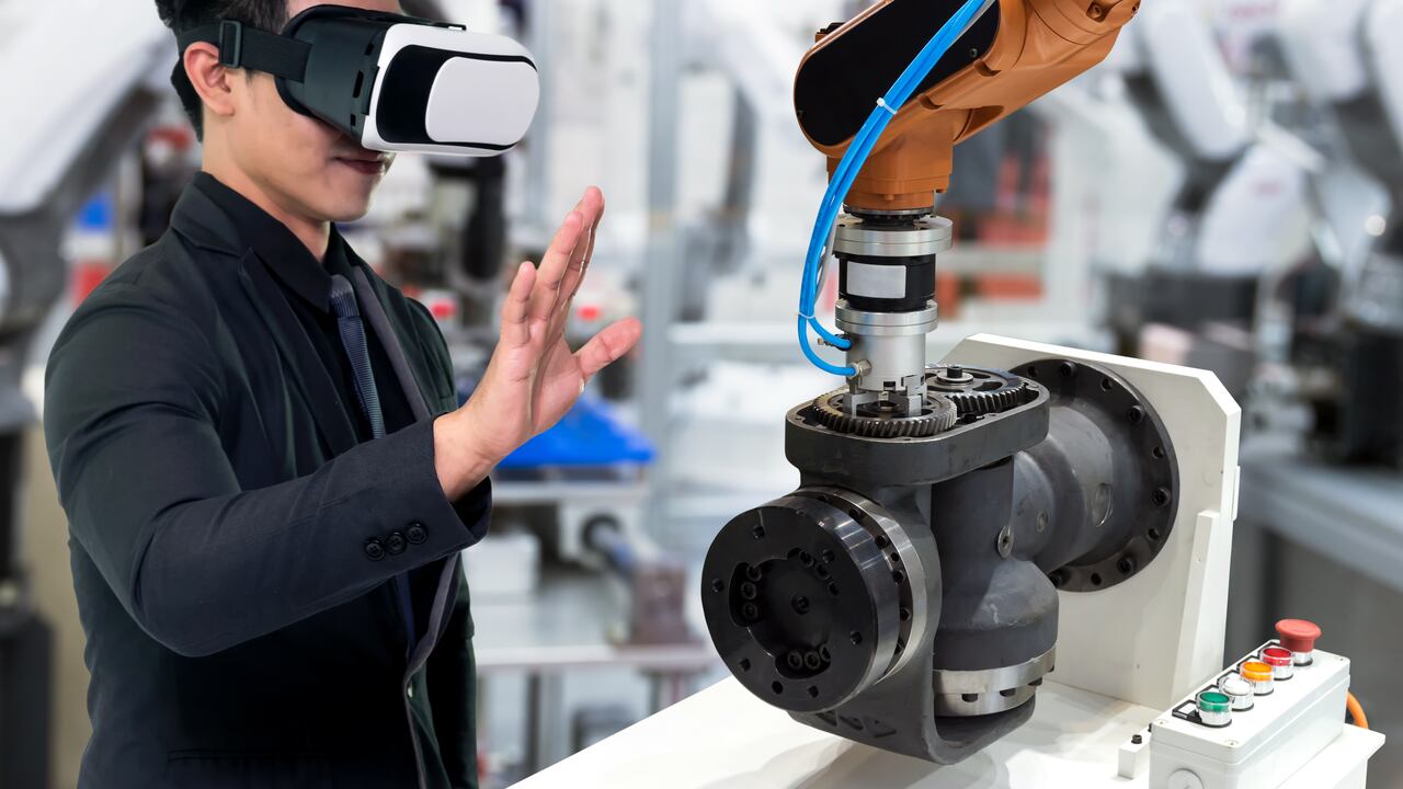 Tecnología de realidad virtual en la industria 4.0. Traje de hombre de negocios con gafas VR para ver el servicio AR, motor de monitoreo térmico para verificar, destruir parte de la máquina de brazo de robot inteligente en fábrica inteligente.
