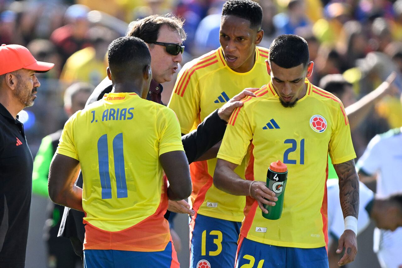 Colombia coach Nestor Lorenzo talks with players Jhon Arias (11), Yerri Mina (13) and Daniel Munoz (21) during the team's international friendly soccer match against Bolivia on Saturday, June 15, 2024, in East Hartford, Conn. (AP Photo/Jessica Hill)