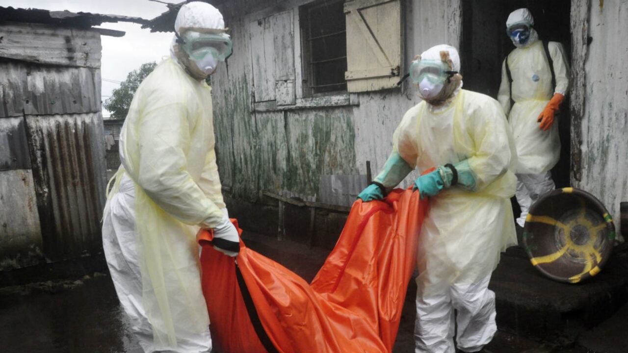Trabajadores de la salud trasladan el cuerpo de una mujer que se sospecha habría muerto de ébola, en las afueras de Monrovia, Liberia, el 8 de octubre, 2014.