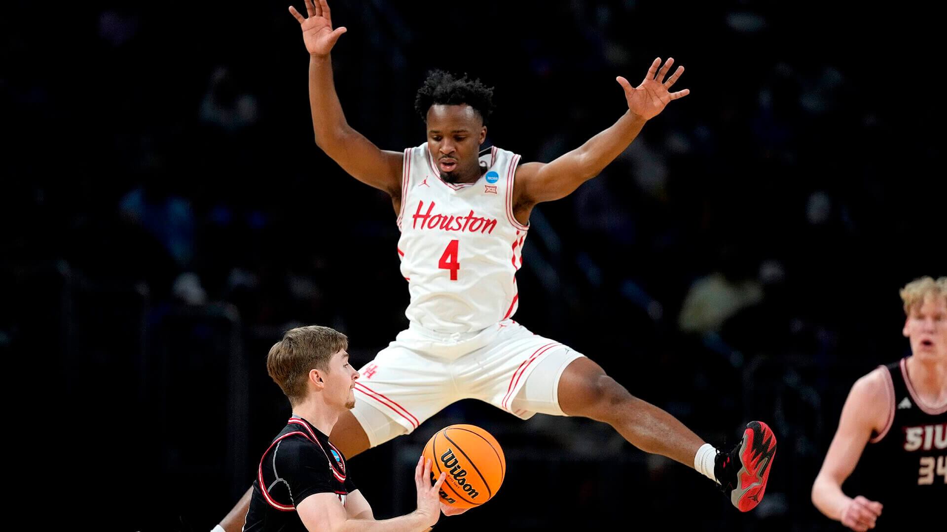 El base de SIU Edwardsville, Declan Dillon, intenta pasar al base de Houston L.J. Cryer (4) durante la primera mitad de un partido de primera ronda del torneo de baloncesto universitario de la NCAA