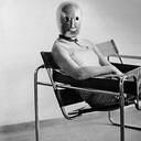Estudiante de la Bauhuaus sentada en la silla Wassily, de Marcel Breuer, con máscara de Oskar Schlemmer.