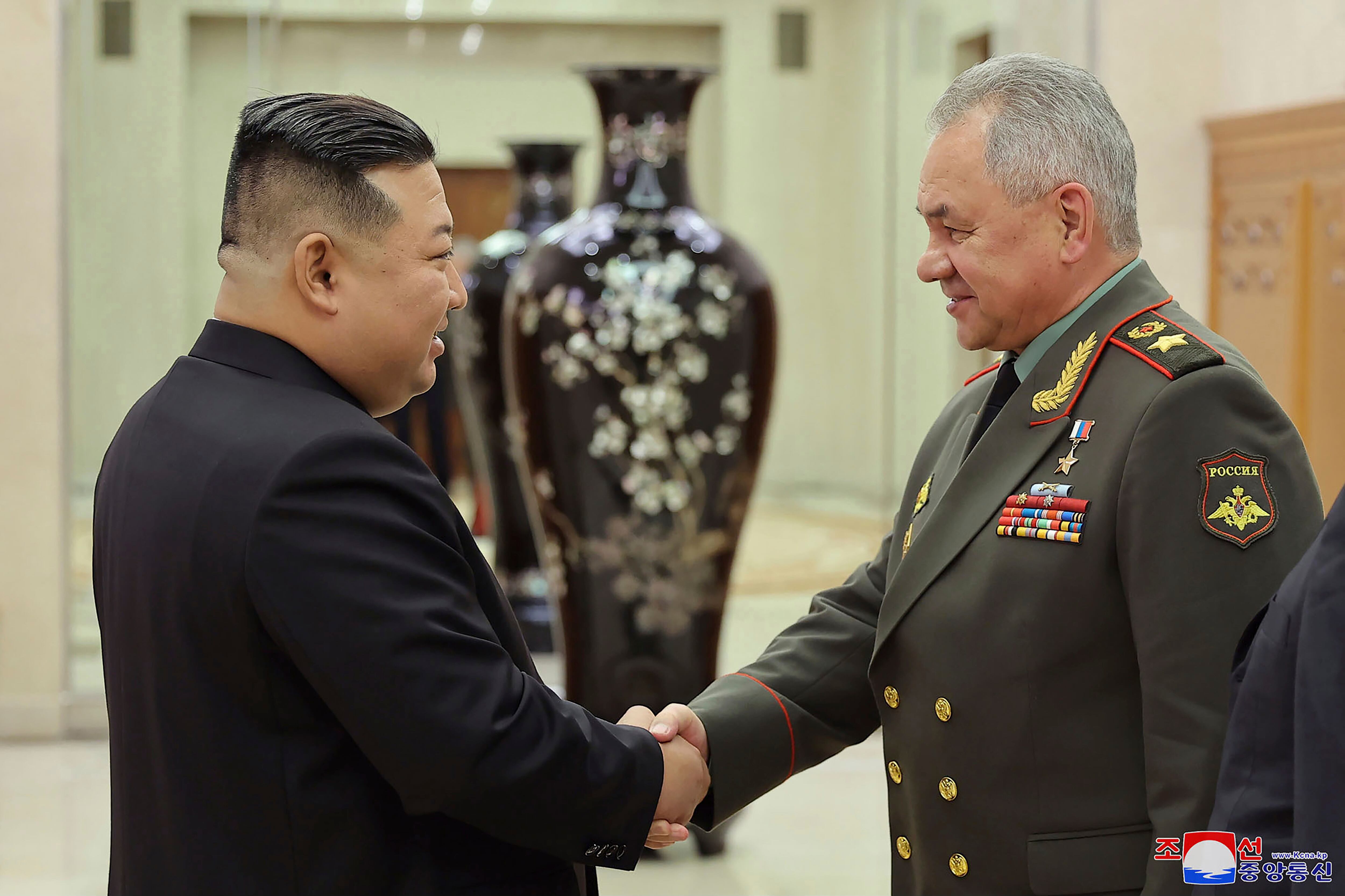 En esta foto proporcionada por el gobierno de Corea del Norte, el líder de Corea del Norte, Kim Jong Un, a la izquierda, le da la mano al ministro de Defensa de Rusia, Sergei Shoigu, en la sede del Comité Central del Partido de los Trabajadores en Pyongyang, Corea del Norte, el miércoles 26 de julio de 2023