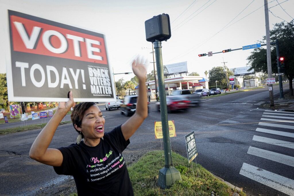 Mary Gallant saluda a los automovilistas mientras los anima a votar en Nueva Orleans, Luisiana, el día de las elecciones, el 5 de noviembre de 2024. (Foto de SANDY HUFFAKER / AFP)