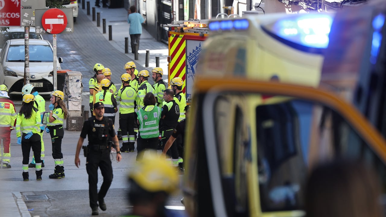 Policías y personal de emergencias cerca del lugar donde se derrumbó un edificio en obras en Madrid.
