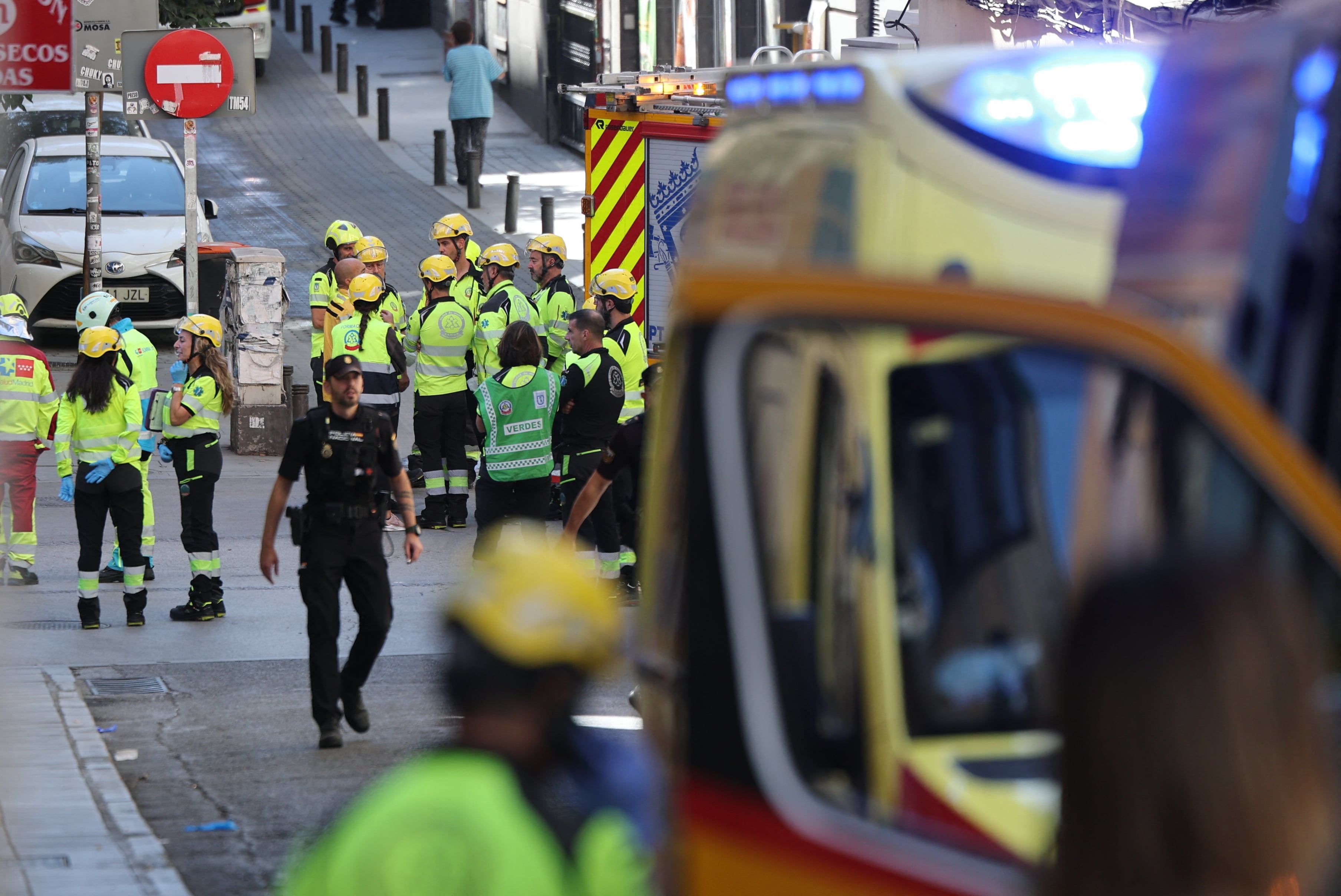 Policías y personal de emergencias cerca del lugar donde se derrumbó un edificio en obras en Madrid.