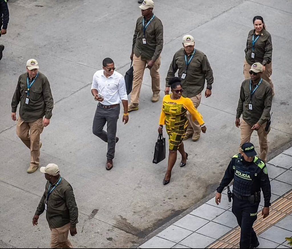 La vicepresidenta Francia Márquez con gafas, cartera, tacones, vestido amarillo, rodeada de escoltas