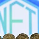 Esta foto de archivo tomada el 30 de diciembre de 2021 muestra una imagen ilustrativa tomada en Londres de monedas de criptomoneda de recuerdo chapadas en oro dispuestas por una pantalla que muestra un logotipo NFT (token no fungible).
Justin TALLIS / AFP