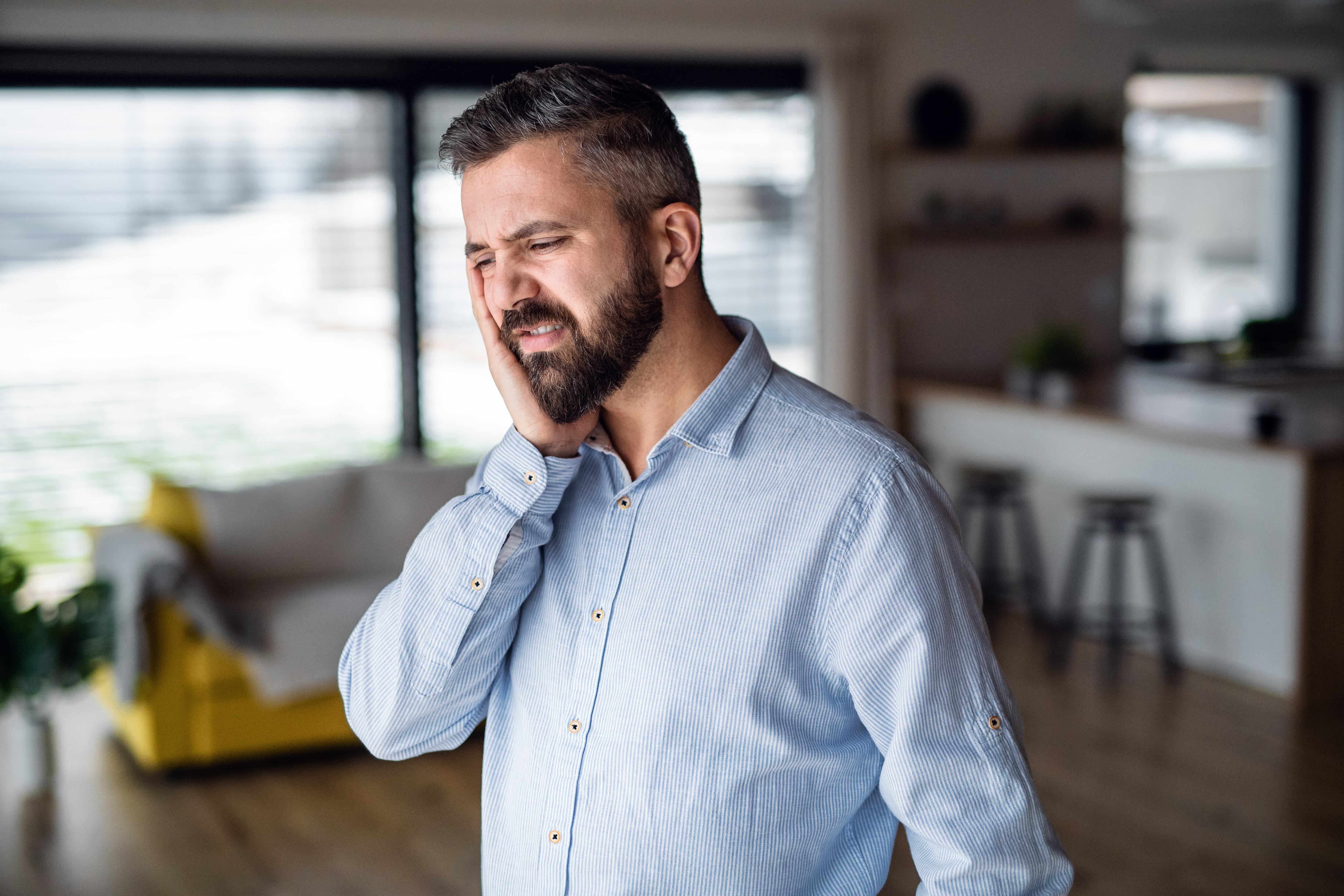 Hombre sufriendo las molestias de la sensibilidad dental