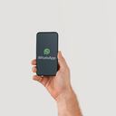 Hand holding smart phone with popular online text / call application "WhatsApp" logo on screen. Illustrative editorial image with copy space for text.