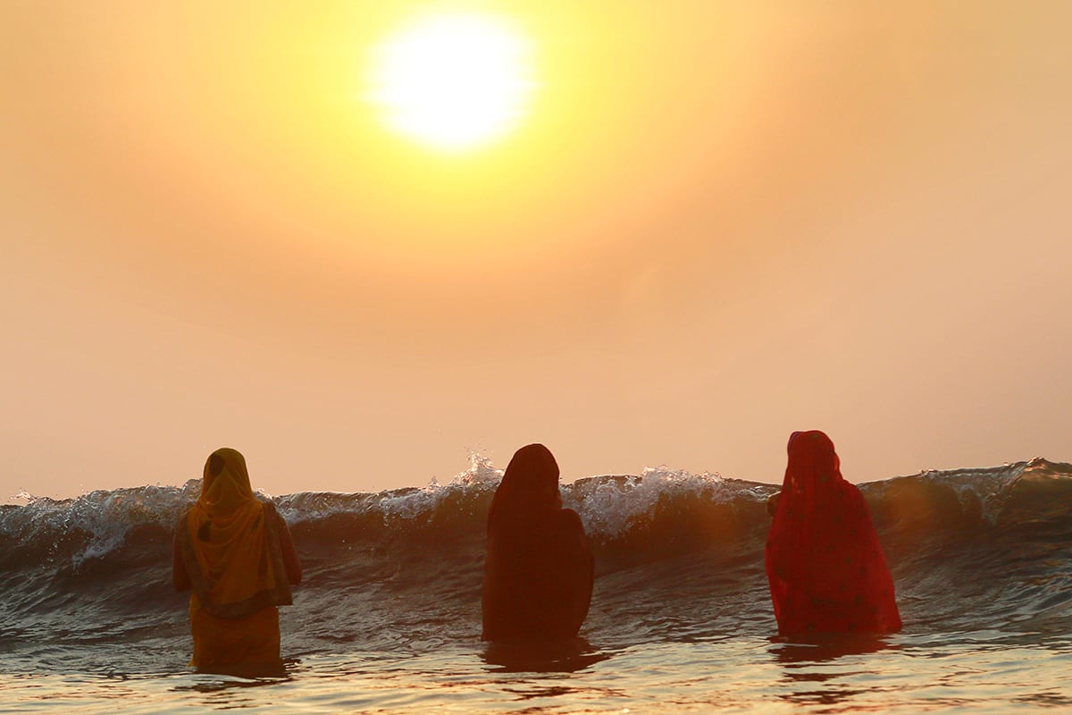 Mujeres hindúes ofrecen plegarias mientras el sol se oculta en el Mar Arabico, durante la celebración del festival Chhtah Puha en Mumbai, India. En el festival se ofrecen rituales al dios del sol, en agradecimiento por la vida en la tierra. (AP)