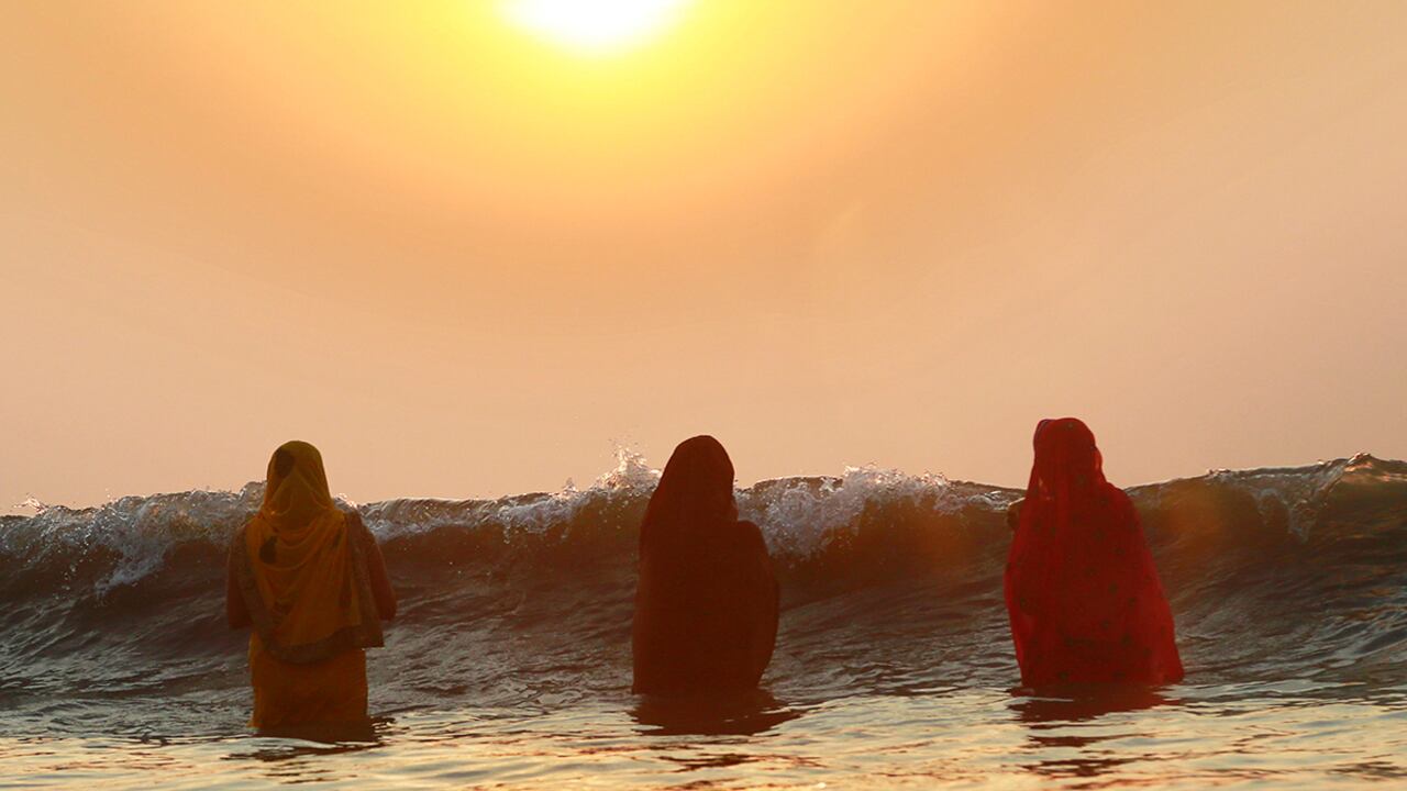 Mujeres hindúes ofrecen plegarias mientras el sol se oculta en el Mar Arabico, durante la celebración del festival Chhtah Puha en Mumbai, India. En el festival se ofrecen rituales al dios del sol, en agradecimiento por la vida en la tierra. (AP)