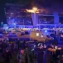 Un hombre habla con los periodistas mientras se ve un incendio masivo en el Ayuntamiento de Crocus en el extremo occidental de Moscú, Rusia, el viernes 22 de marzo de 2024.