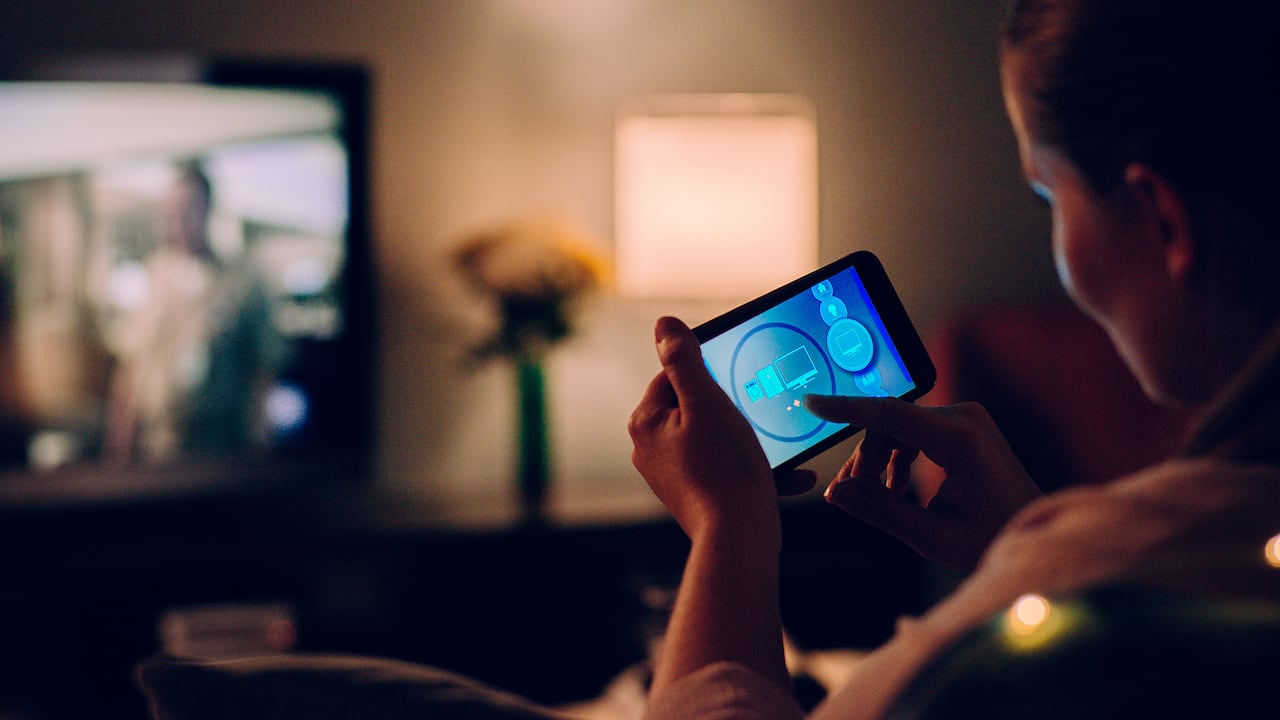 Mujer con aplicación móvil en casa. Mujer con celular