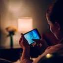 Woman using mobile app at home in front of tv.
