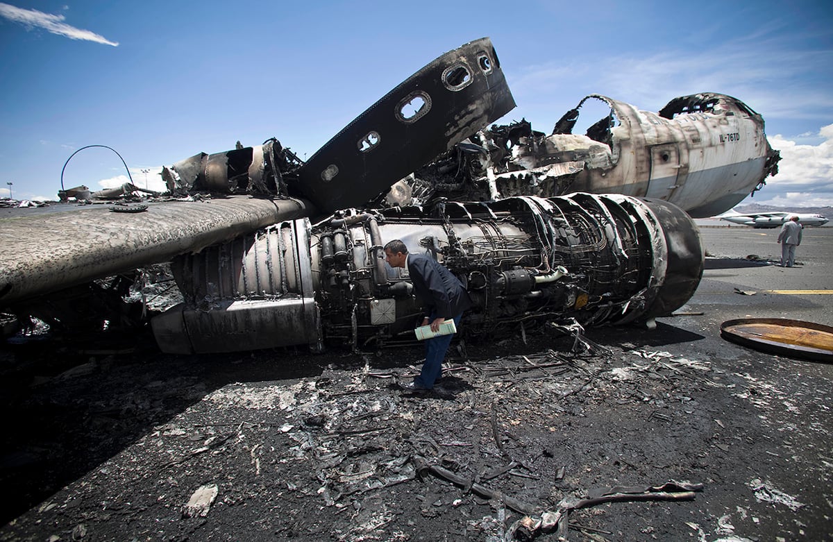 Un oficial observa un avión militar destruido por los ataques aéreos dirigidos por saudíes en el Aeropuerto Internacional de Saná, Yemen. (AP/Hani Mohammed)