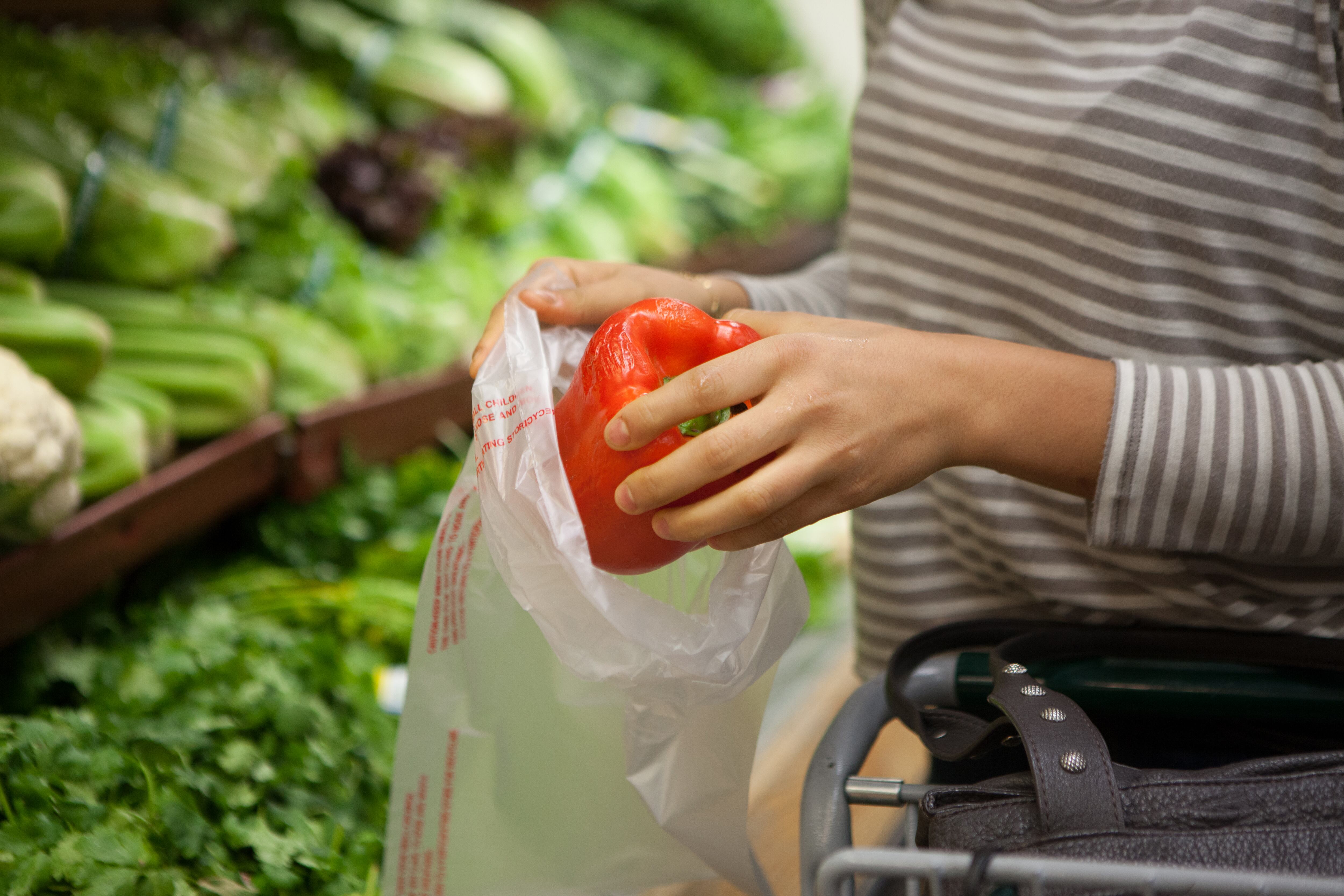 Cropped shot of young woman selecting red pepper at health food store
