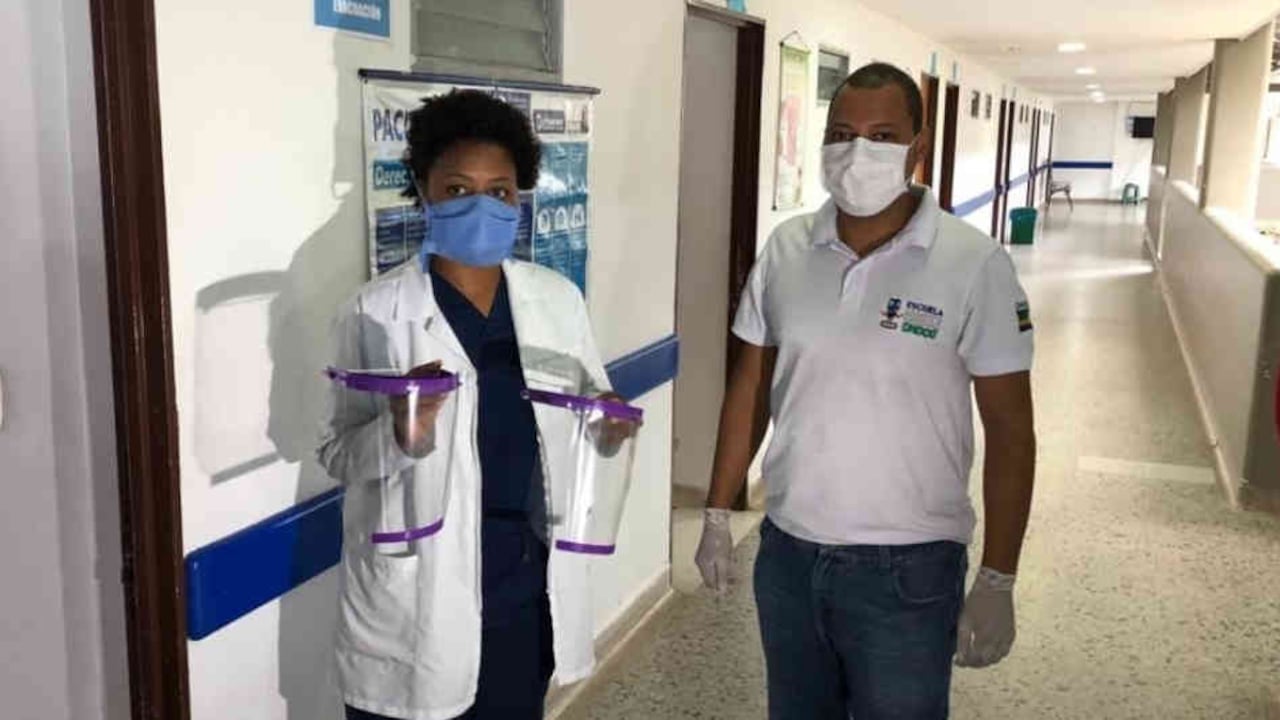 Jimmy García, fundador y profesor del club entrega las caretas a una médica en un hospital de Quibdó.